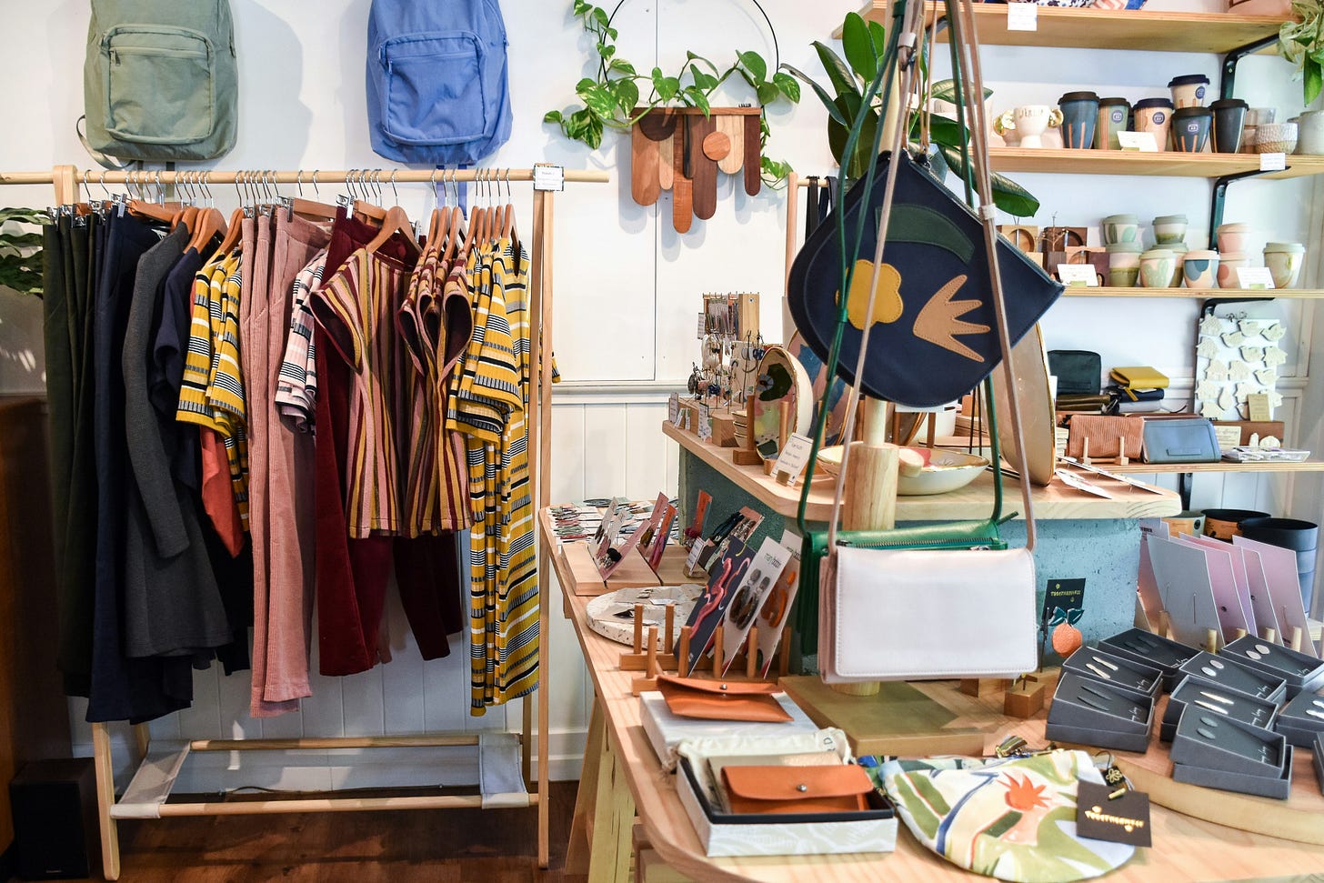 medium shot of boutique interior with colorful clothes, backpacks, and accessories displayed for sale medium shot of boutique interior with colorful clothes, backpacks, and accessories displayed for sale