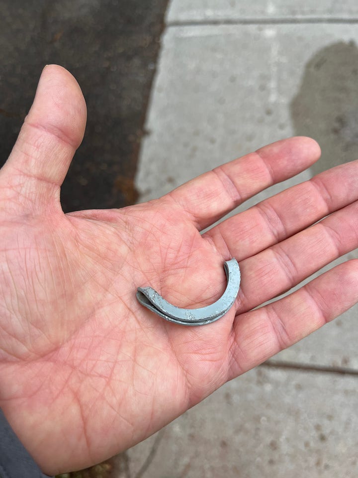 Open hands holding metal objects picked up off the ground.