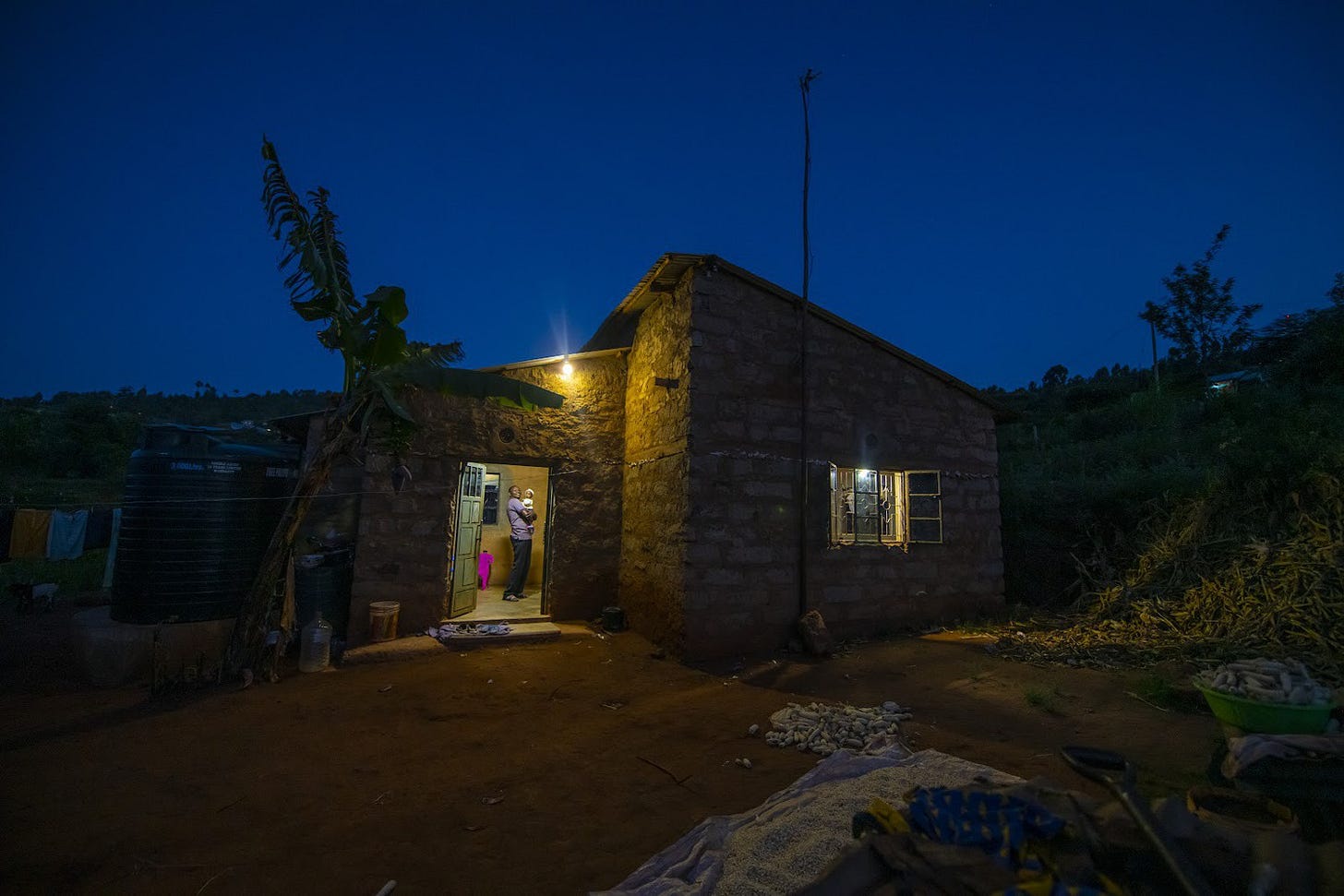 A modest brick home is illuminated at night in Sun King’s Kenya press collection.