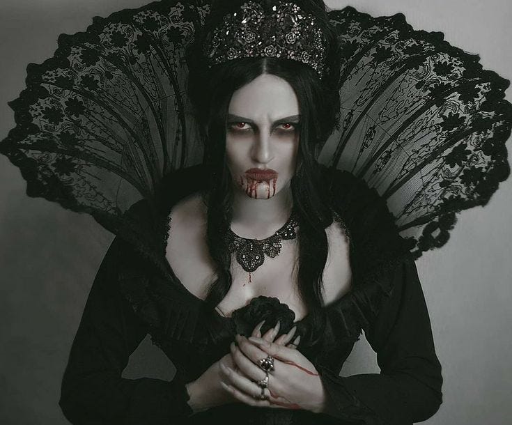 This may contain: a woman dressed in gothic clothing holding an umbrella over her head with blood dripping from her mouth