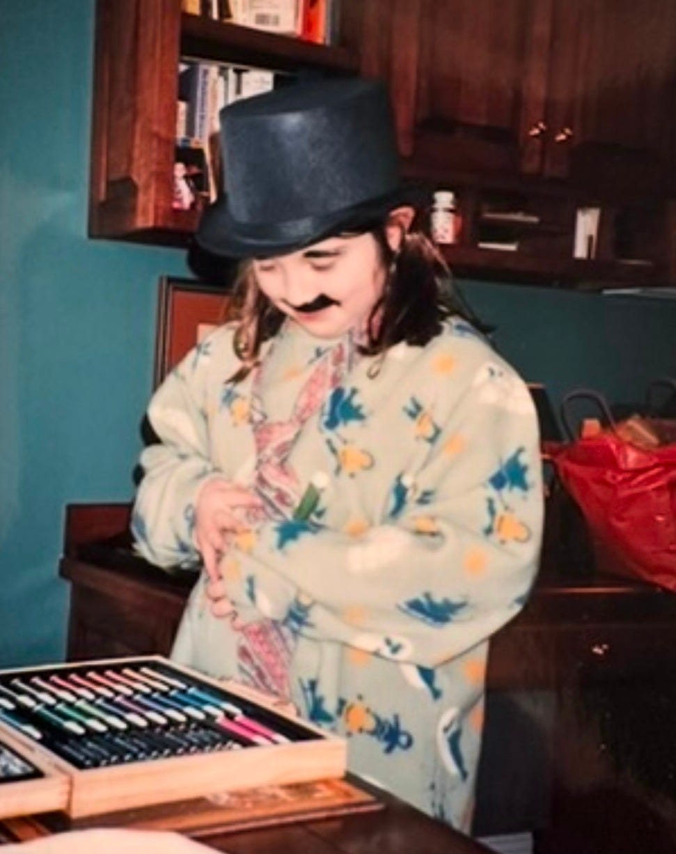 Young Raf, in Groucho Marx facepaint and a top hat, surveying a box of markers