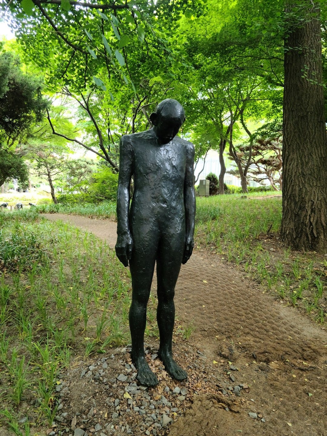a statue of a man standing in the middle of a park