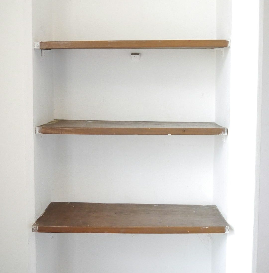 empty shelves in a white room with a tile floor empty shelves in a white room with a tile floor