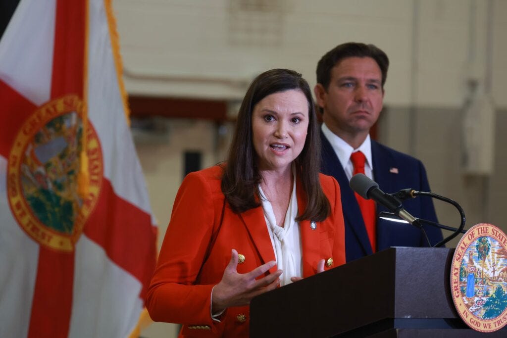 U.S. Senator Ashley Moody speaks while Florida Governor Ron DeSantis looks on.