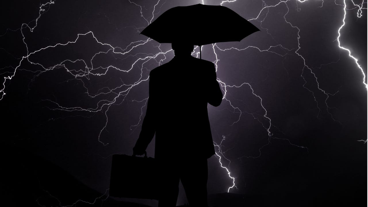 Silhouette of a man walking into a lightening storm carrying an umbrella