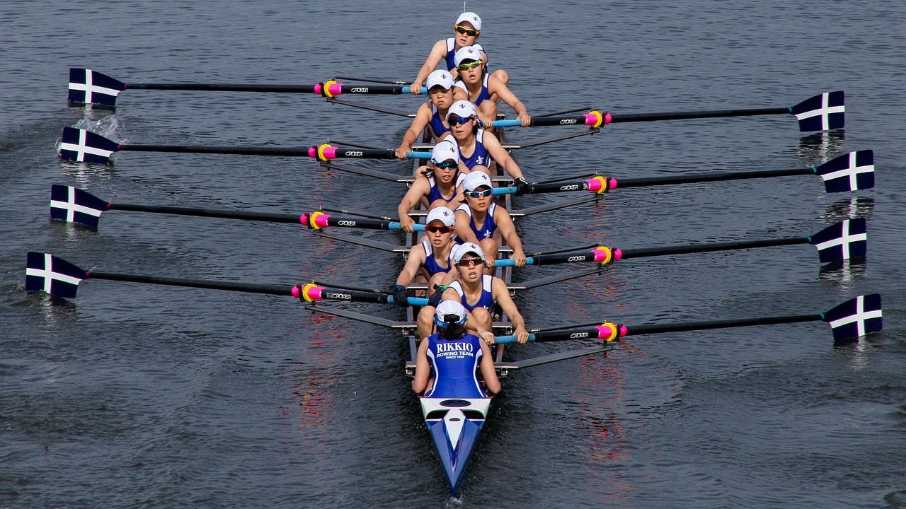 A rowing eight gliding across the water, each rower in perfect sync with the others, symbolising team alignment, cohesion, and shared direction. A rowing eight gliding across the water, each rower in perfect sync with the others, symbolising team alignment, cohesion, and shared direction.