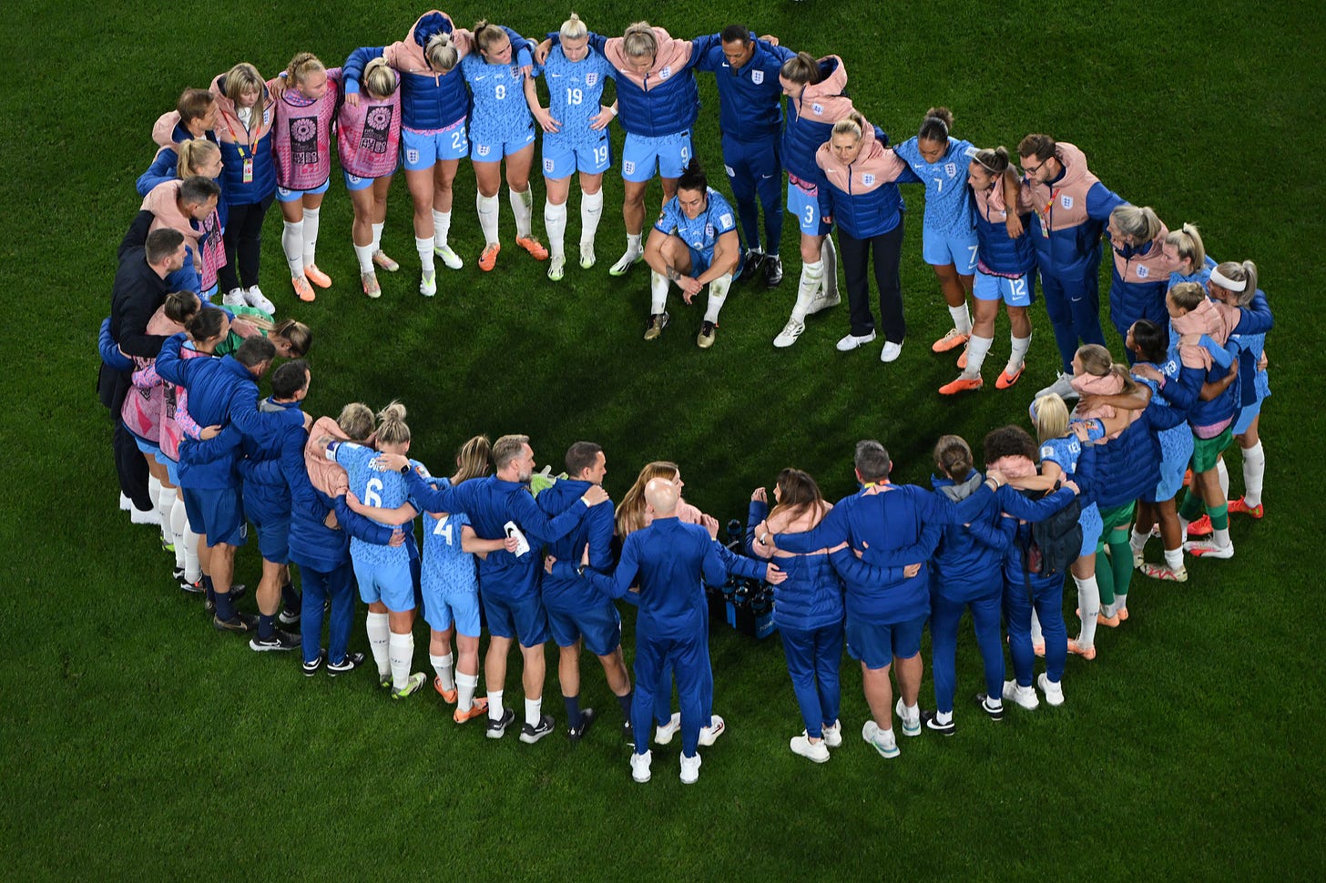 The England players and staff huddle after the game.