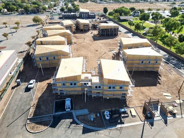 A building under construction with cars and trees

AI-generated content may be incorrect.