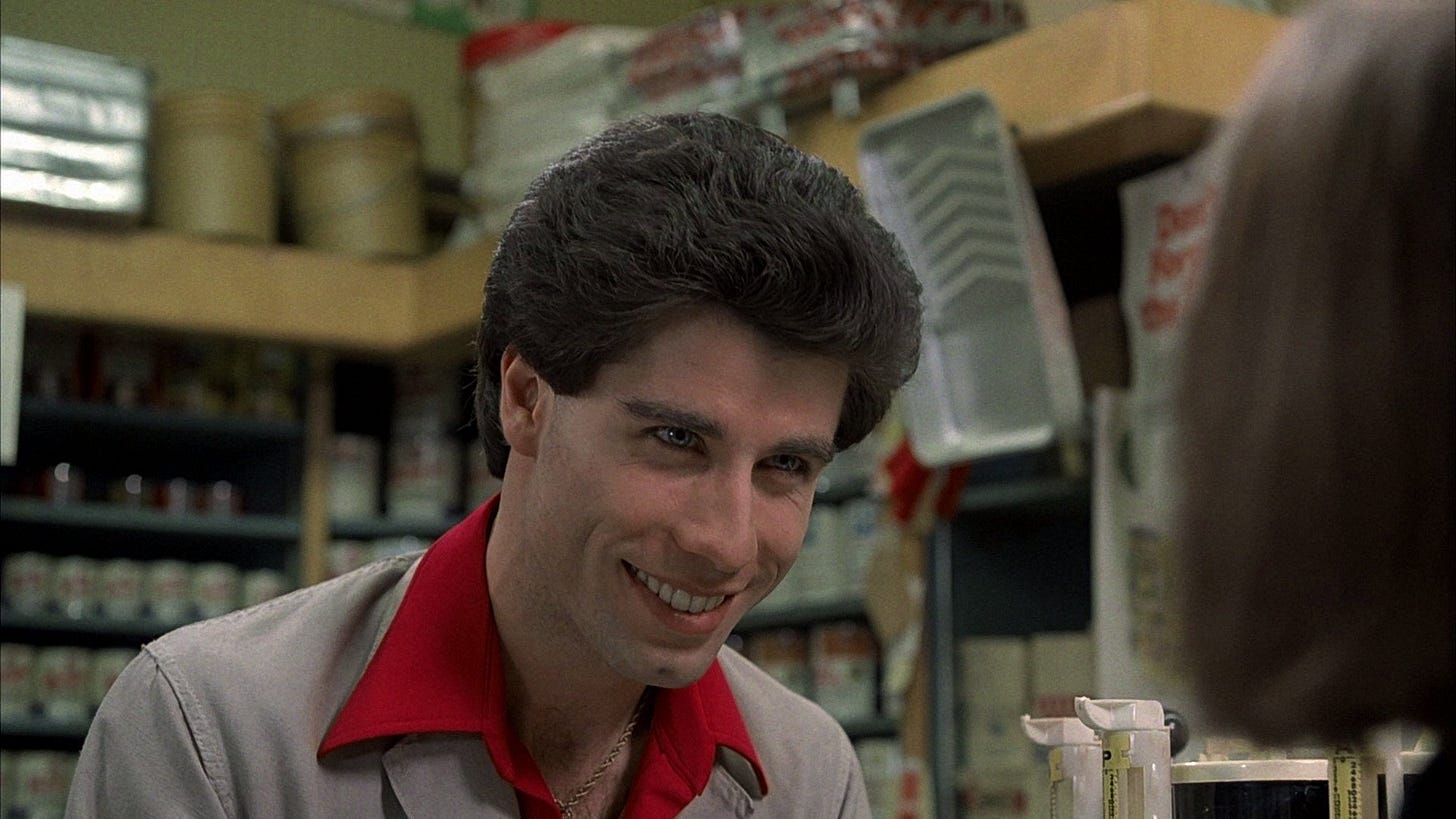 Tony Manero behind the counter at the paint store. Tony Manero behind the counter at the paint store.