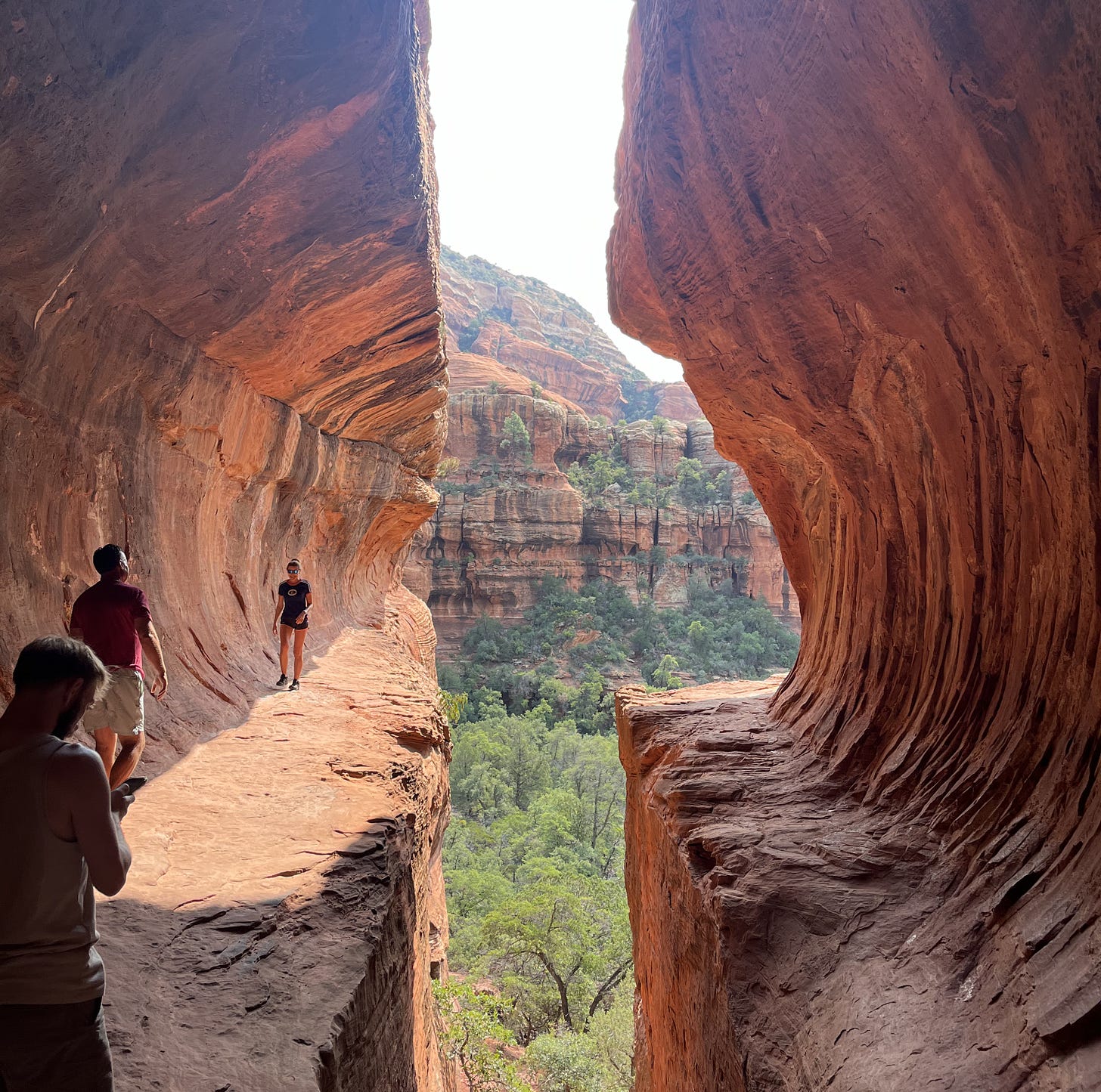 The iconic red rock tunnel of the Subway Cave in Boynton Canyon, Sedona, a popular hidden gem hike for families