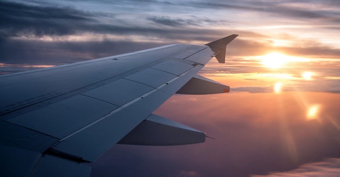 white airplane wing during sunset
