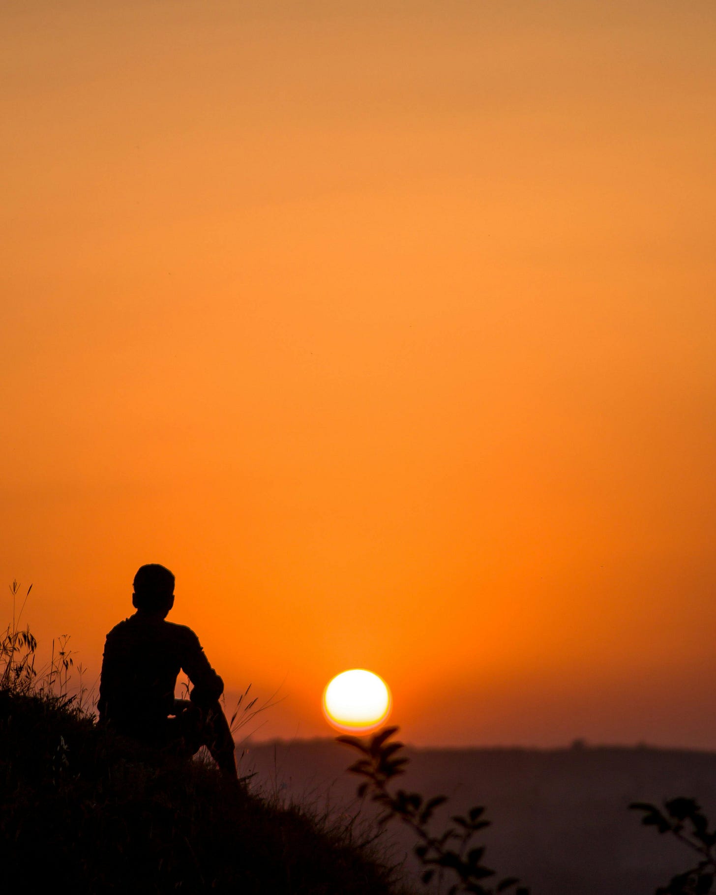 Silhouette of Sitting Person at Sunset Silhouette of Sitting Person at Sunset