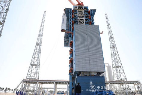 The Long March 8A's first and second stages being placed onto Commercial Launch Pad 1, while its fairing heads to the launch site.