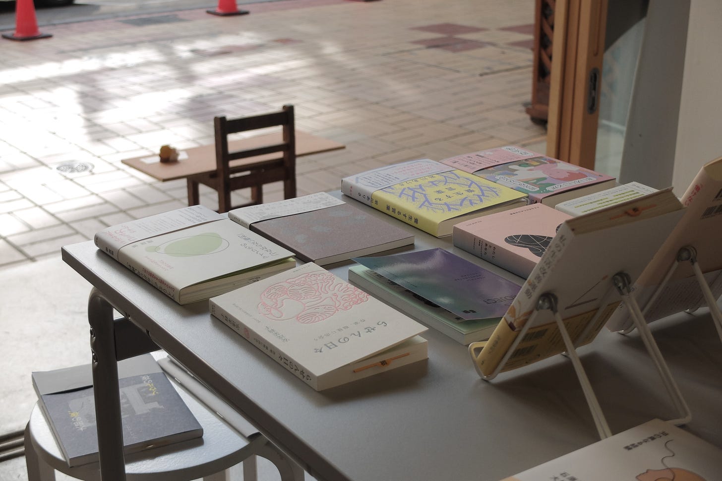 店内の画像。手前に本が並べられたテーブル、奥に店外の道路が写っている。