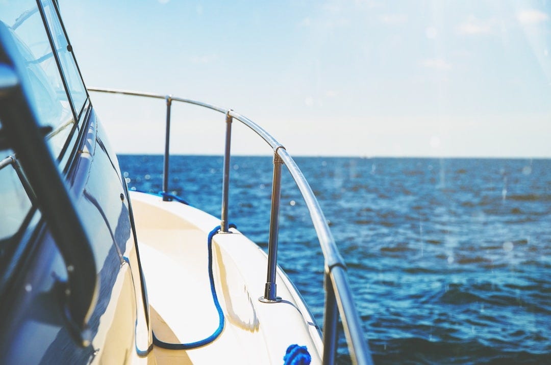 photo of white and gray ship in body of water photo of white and gray ship in body of water