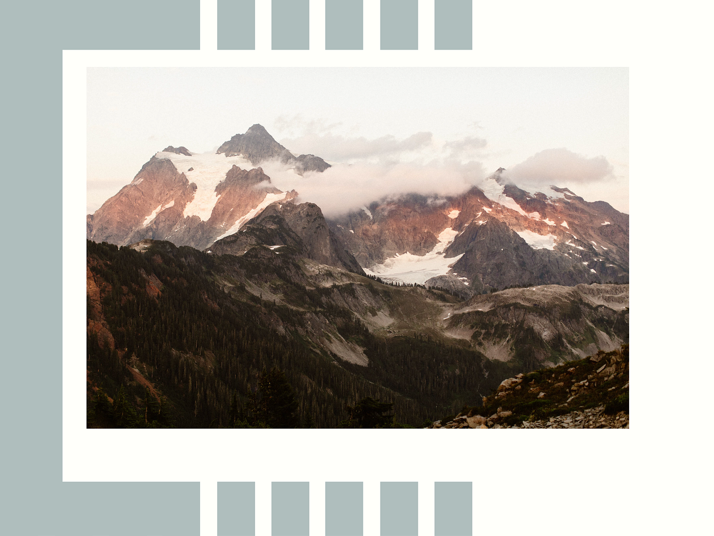 maroon alpenglow hitting the peaks of snow dotted mountains