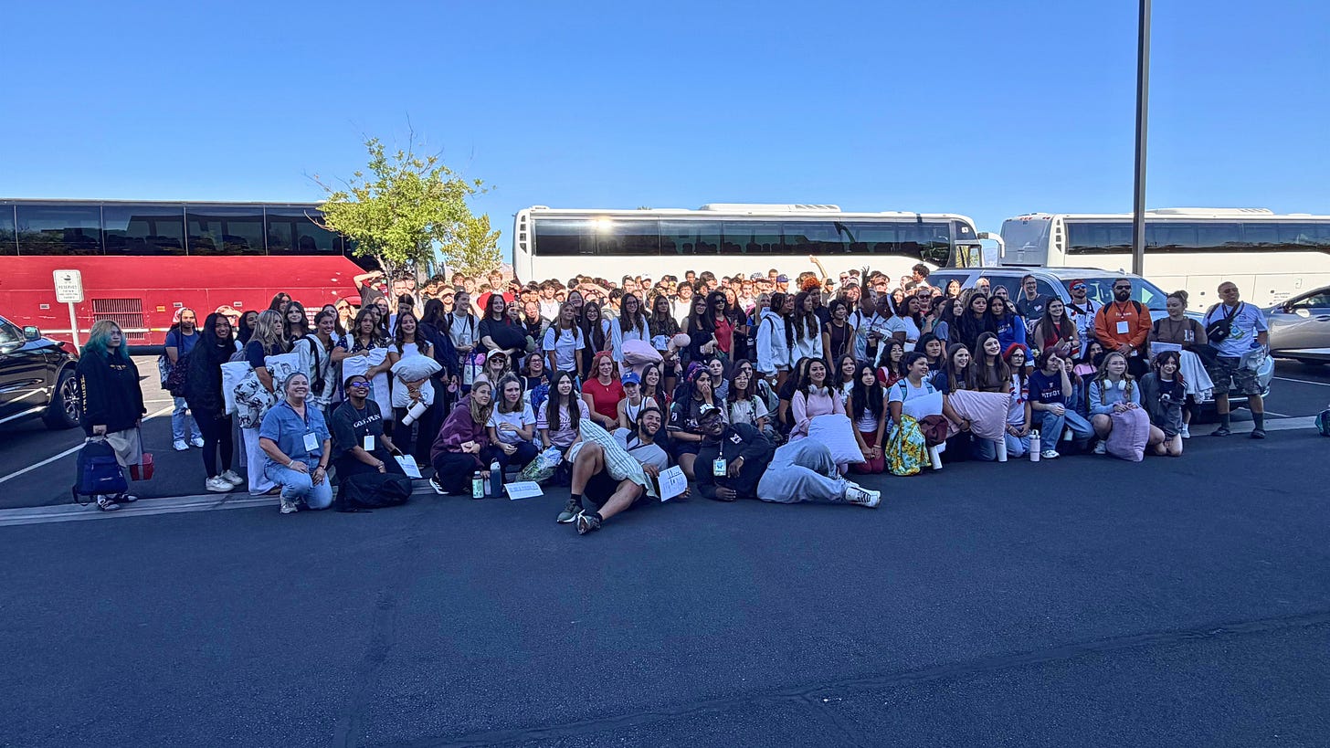 grou pof teens in front of buses going to camp