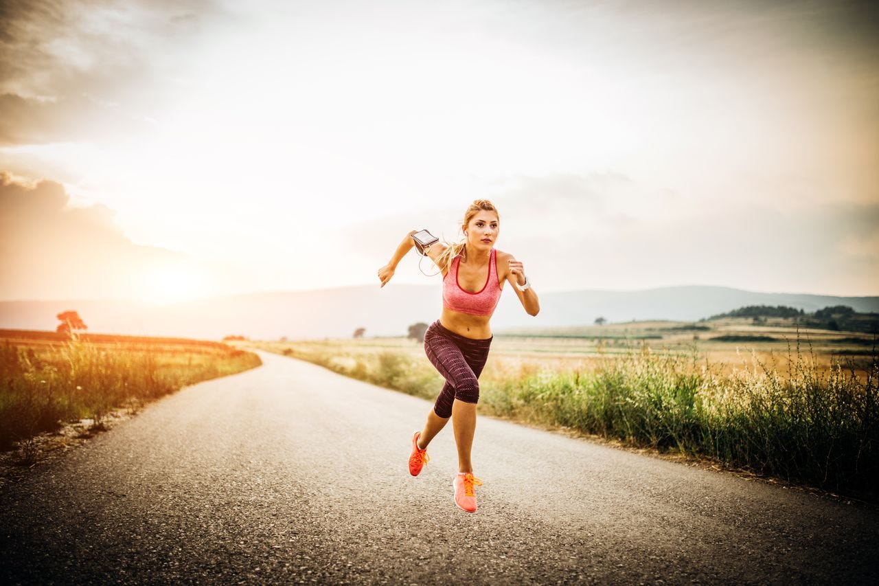 Woman sprinting down a country lane