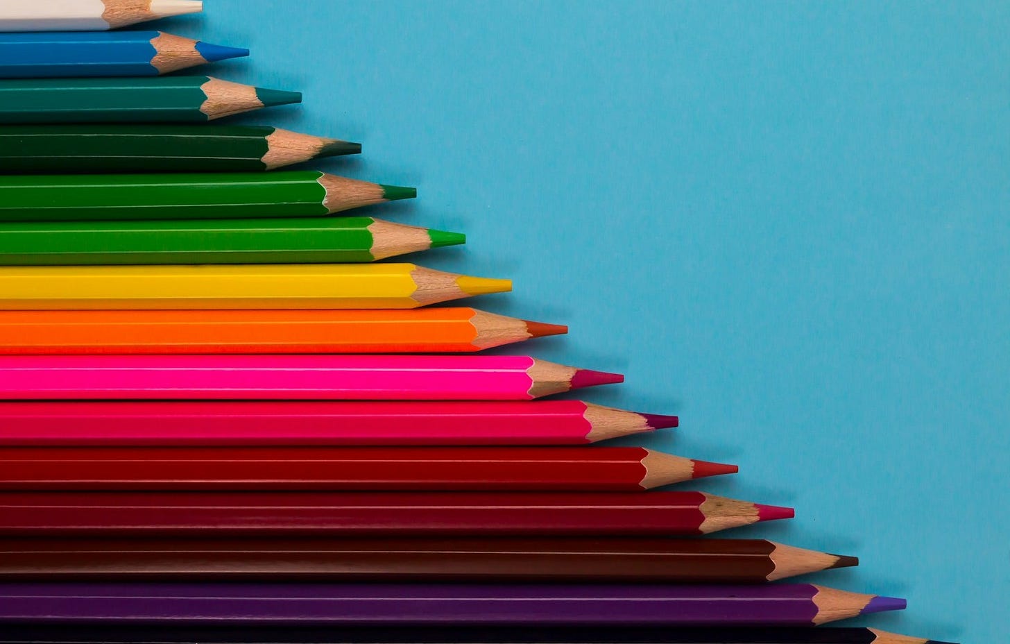 multi colored pencils on pink surface