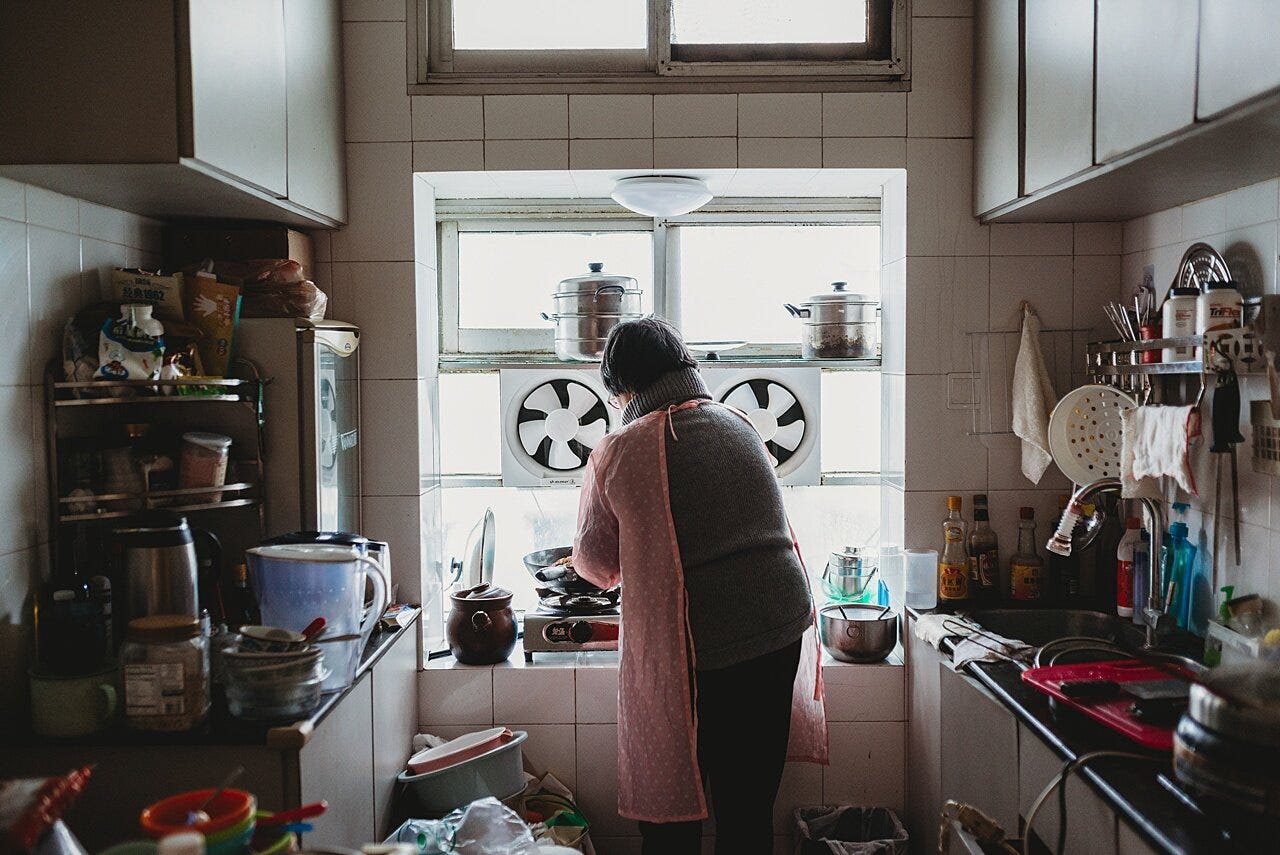 a woman cooking a meal in a small apartment kitchen in wuhan china during initial covid outbreak documented by phoenix family photographer amy dangerfield when she was visiting family in Wuhan China.