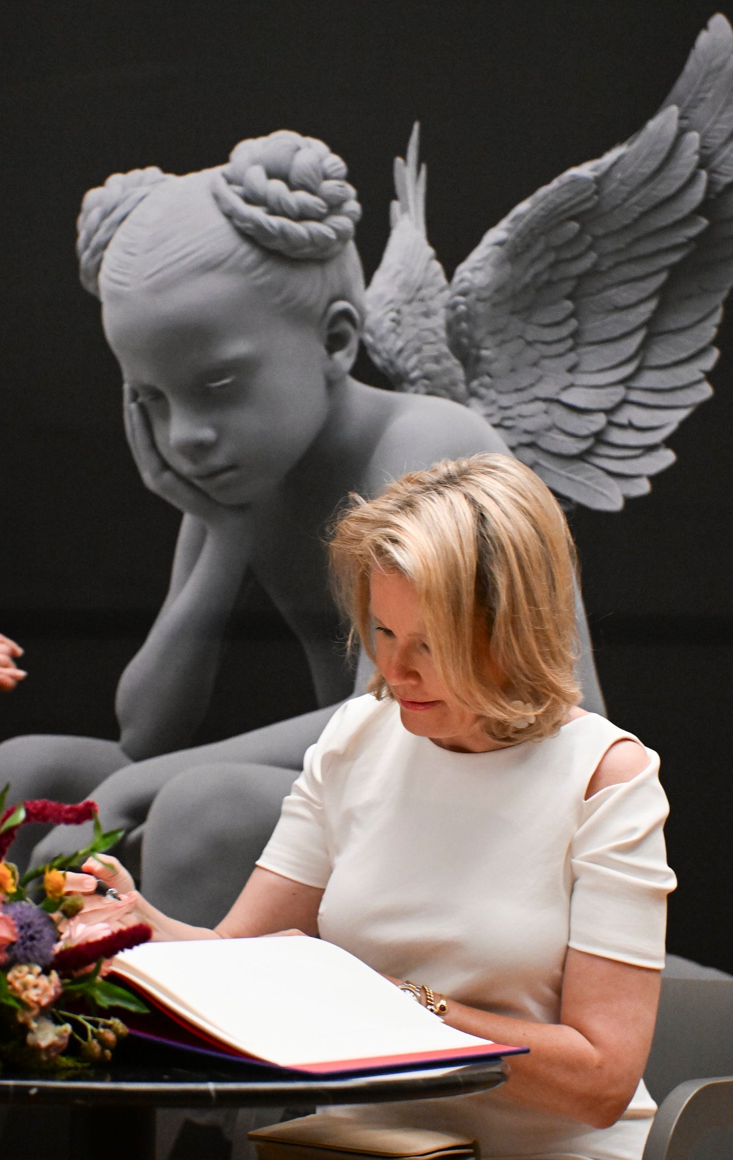 Queen Mathilde signing a book