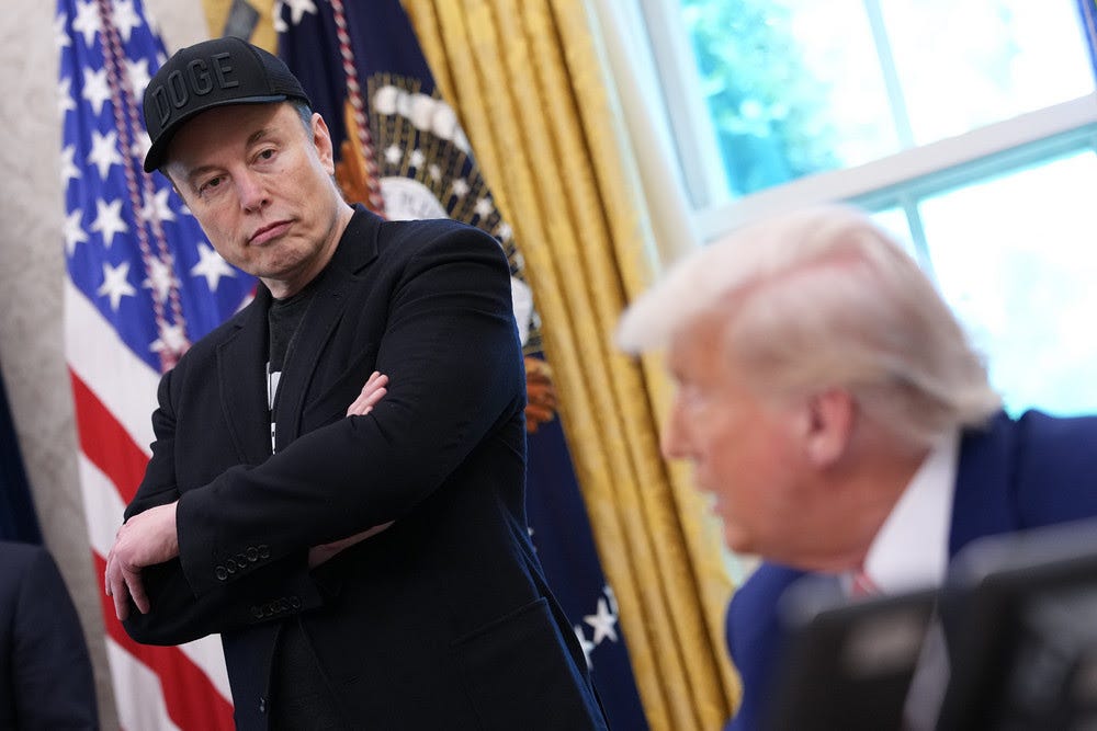 Tesla CEO Elon Musk listens as President Donald Trump speaks to reporters in the Oval Office of the White House.