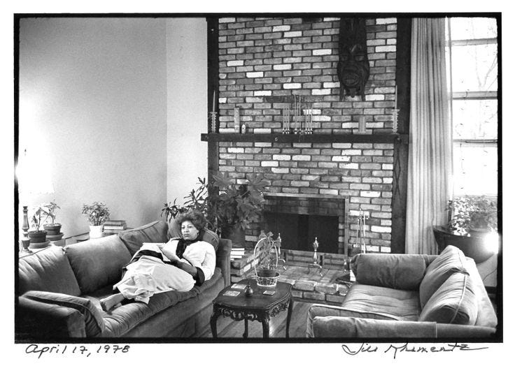 This may contain: an old black and white photo of a person laying on a couch in front of a fireplace