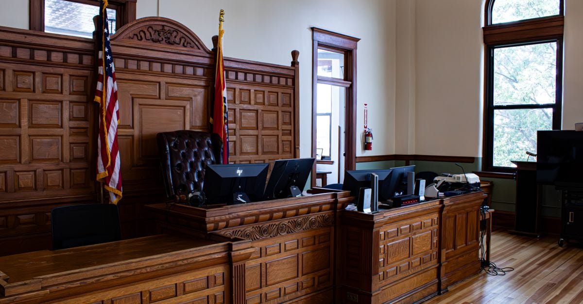 Photo: Zachary Caraway / Pexels Interior view of an American courthouse in Kirksville, Missouri, featuring a judge's desk and flags.