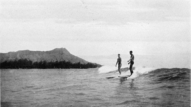 surfers catch a wave