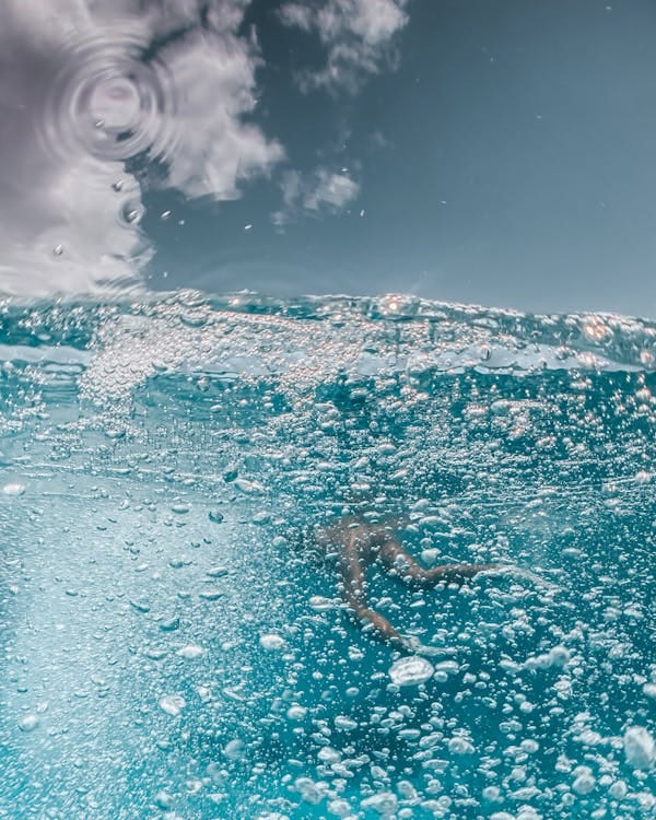 Free A mesmerizing underwater view of snorkeling in azure blue water with bubbles and sunlight. Stock Photo