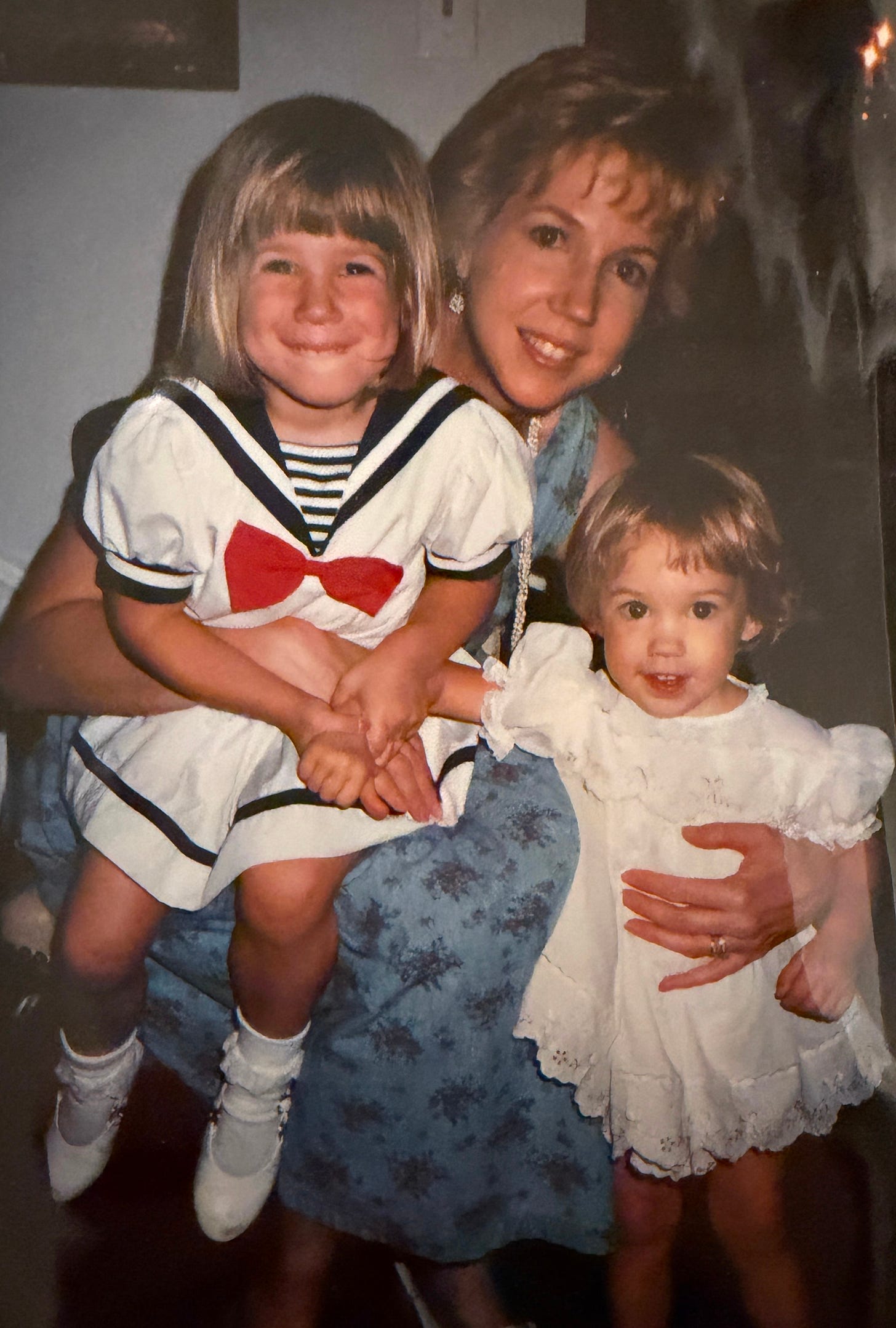 The author holding her two young daughters on her lap.
