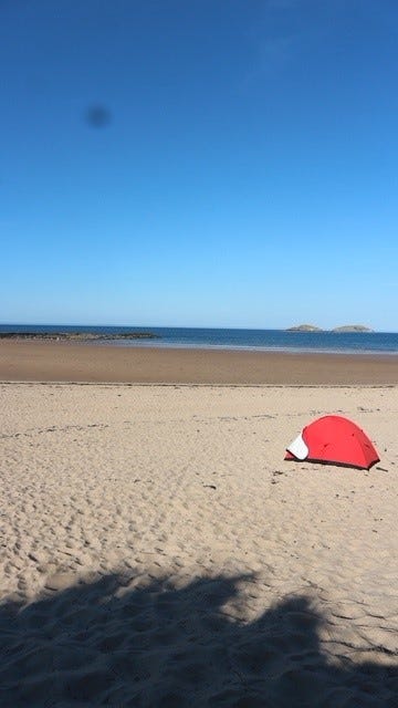 image of a sunny sandy beach, blue sky and a little red two man tent