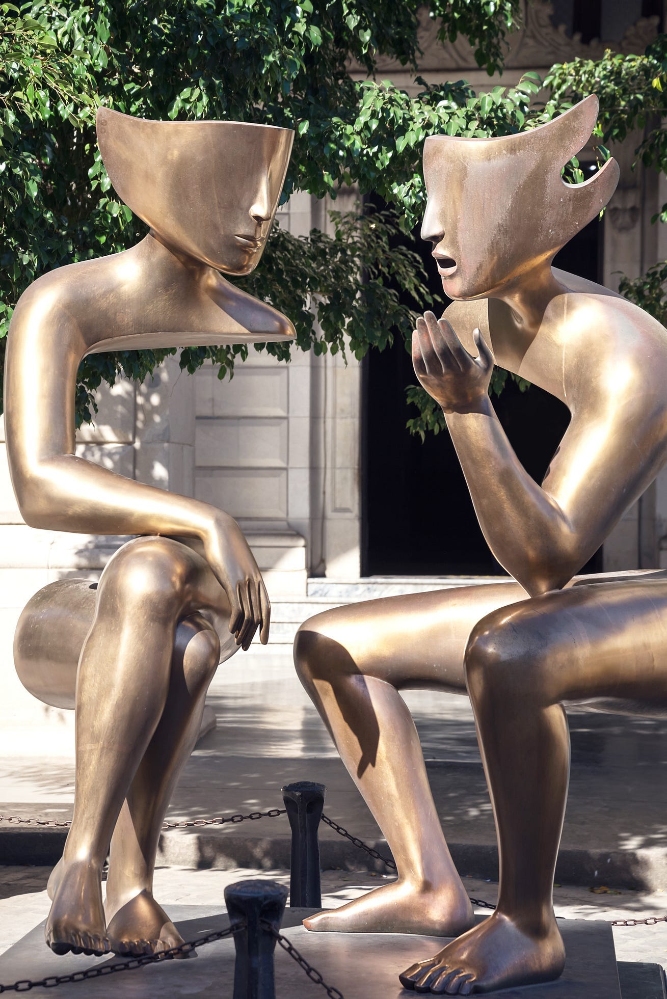 Sculpture Conversation in the city street — 2 bronze figures sitting Sculpture Conversation in the city street — 2 bronze figures sitting