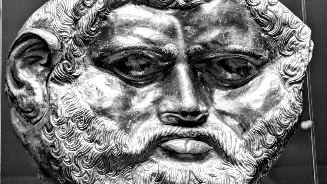 A close up of a gold statue of a man