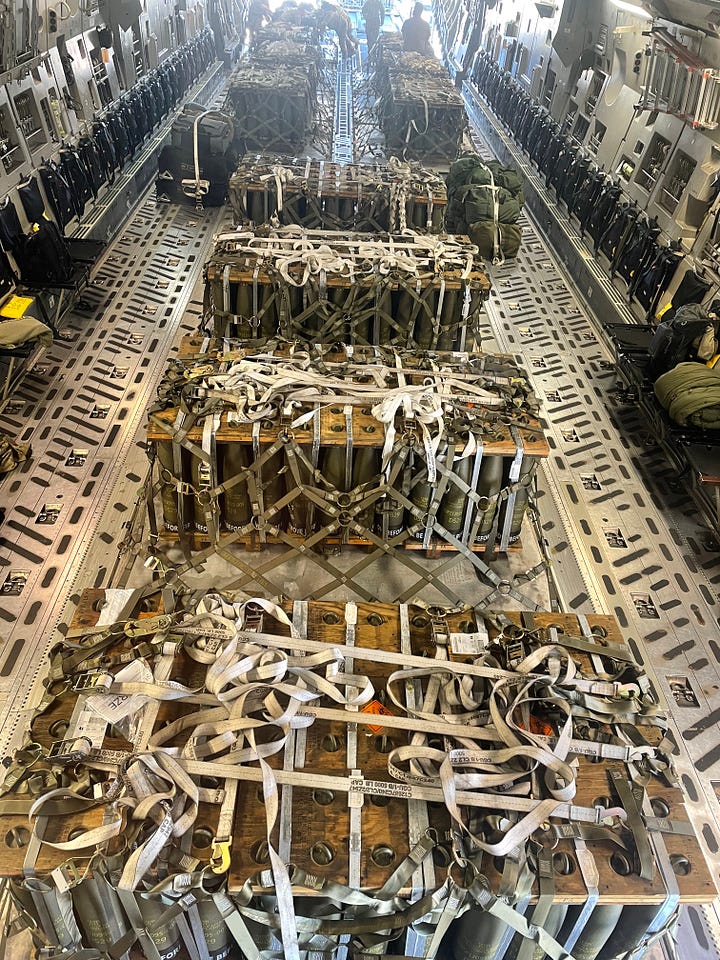 C-17 cargo bay with ammunition and C-17 cargo bay with loadmasters playing cards on a makeshift table