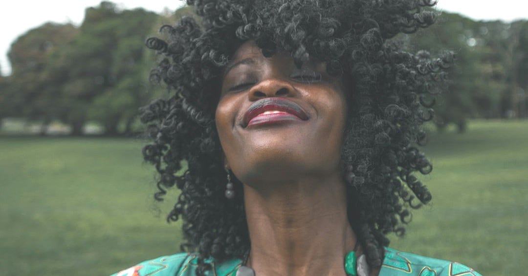 woman in green plunging neckline top with right arm on her waist woman in green plunging neckline top with right arm on her waist