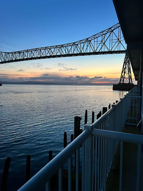 1. Tugboat going under a bridge at sunset. 2. Freighter on the Columbia River. 3. Astoria-Megler Bridger in sunrise. 4. Ships on the Columbia River with pilings. 5. Binoculars. 6. Big ship on the Columbia River. 7. View of the Columbia and Pacific Ocean from the Astoria Column. 8. Photo of Rose smiling from the Astoria Column. 9. View of downtown Astoria and the Columbia River