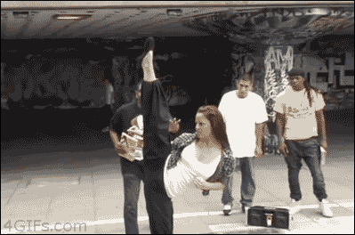 A woman kicks a book into a bag held by a man several feet away. A woman kicks a book into a bag held by a man several feet away.