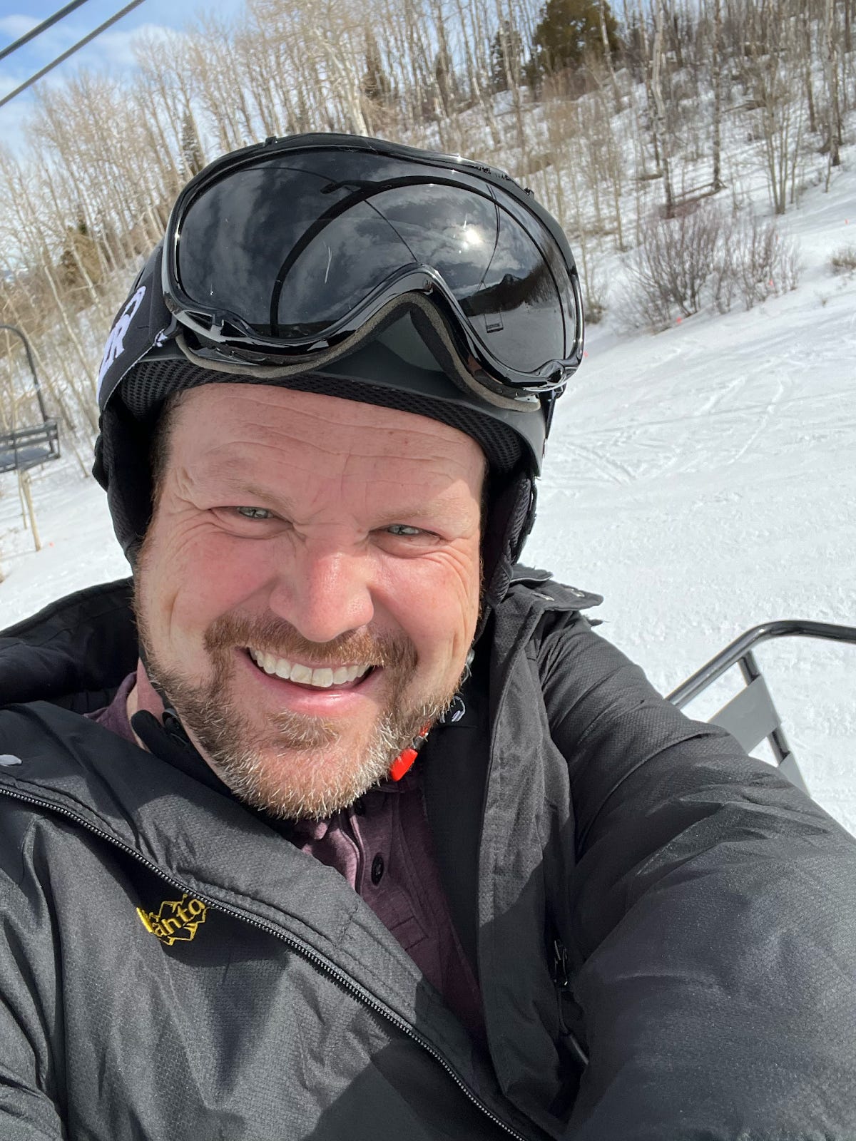 A middle-aged man trying something new - riding a ski lift up a mountain for the first time. He has the smile of someone who has no clue what he’s doing or what he’s gotten himself into. A middle-aged man trying something new - riding a ski lift up a mountain for the first time. He has the smile of someone who has no clue what he’s doing or what he’s gotten himself into.