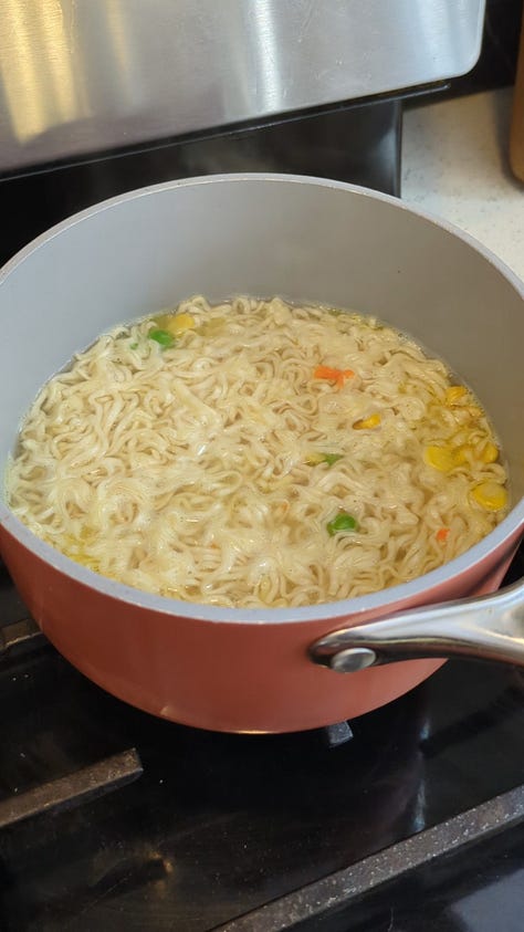 Classic chicken instant ramen cup being opened, cooked, and held up by chopsticks.