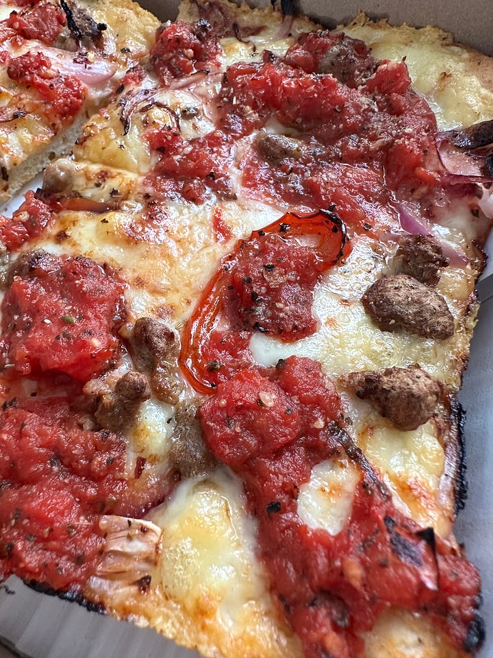 A beautiful pizza and black bean burger with a shake.