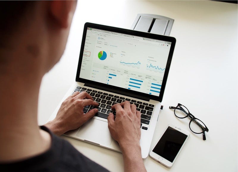 Professional reviewing search performance metrics and click-through data on a computer monitor