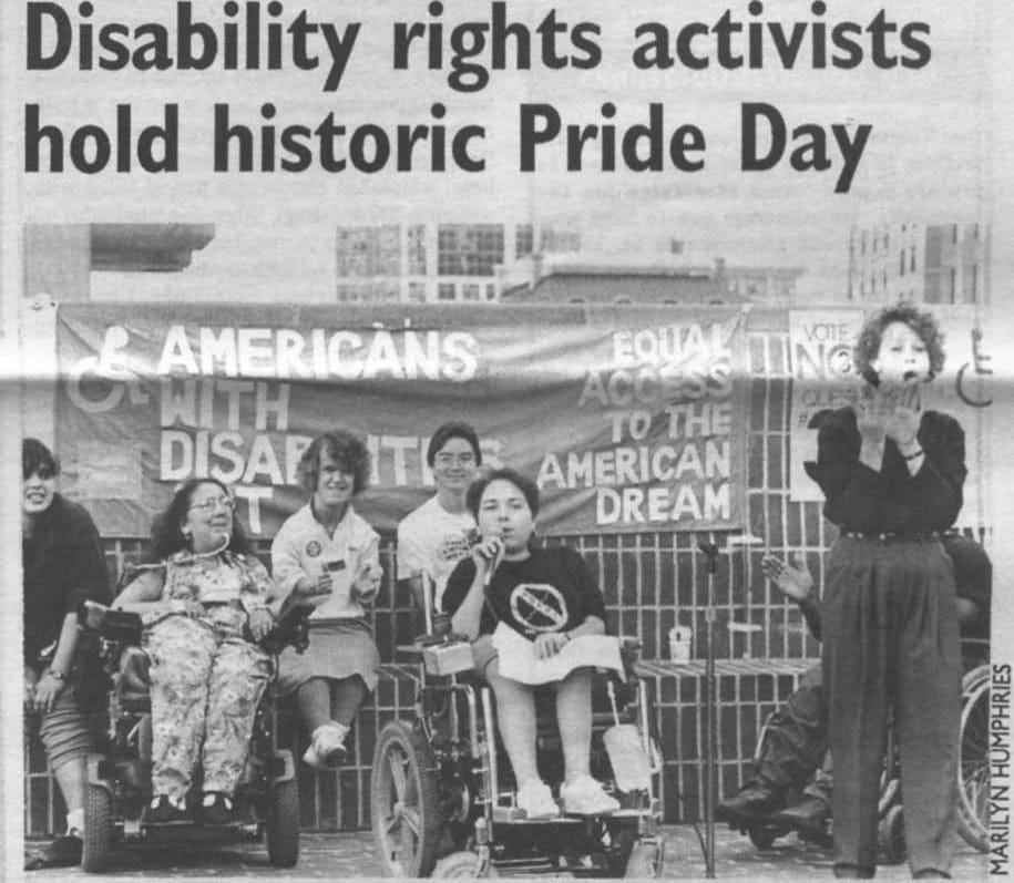 An old newspaper article with the headline, Disability rights activists hold historic Pride Day. In a black and white photo, disabled activists lead a rally. A wheelchair user holds a mic with an ASL interpreter nearby. A sign says Americans with Disabilities Act. Equal access to the American dream. An old newspaper article with the headline, Disability rights activists hold historic Pride Day. In a black and white photo, disabled activists lead a rally. A wheelchair user holds a mic with an ASL interpreter nearby. A sign says Americans with Disabilities Act. Equal access to the American dream.