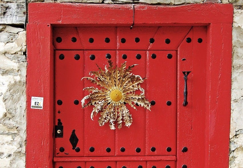 Flor Eguzkilore, protectora y con forma de sol en una puerta de Euskadi. Flor Eguzkilore, protectora y con forma de sol en una puerta de Euskadi.