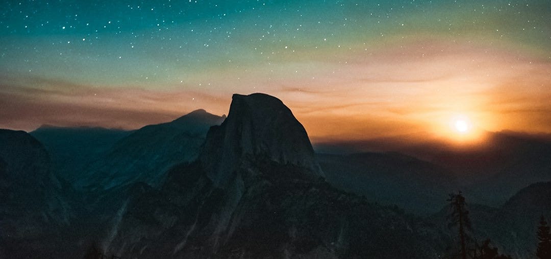 high-angle photography of mountain at sunset