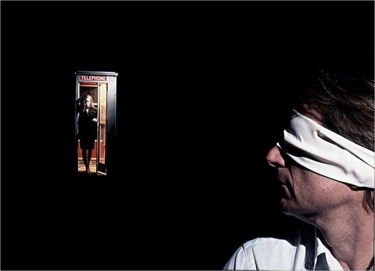 This may contain: a man with blindfolded head standing in front of an open door and looking at himself