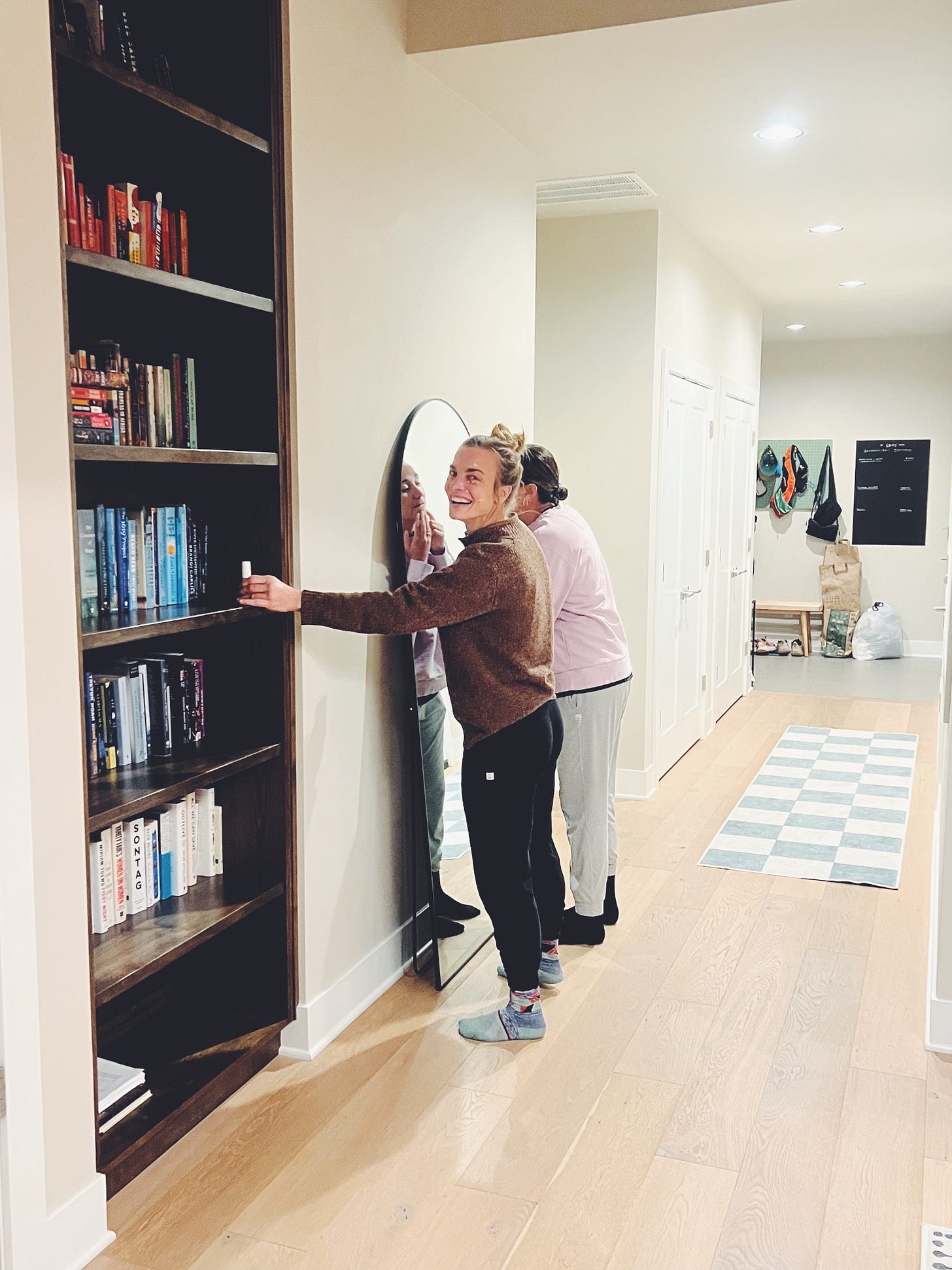 Two gals trying on makeup in the hallway