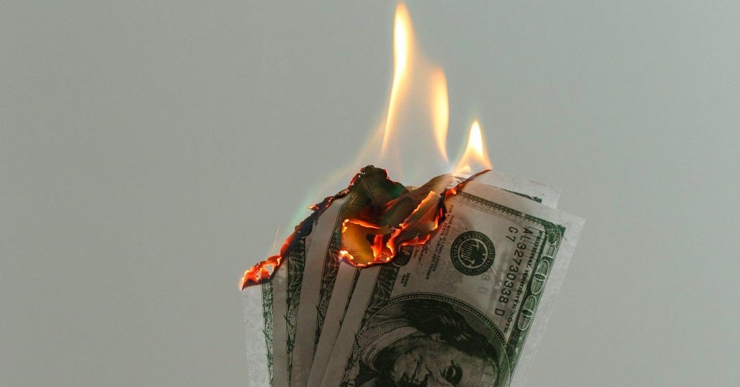time lapse photography of several burning US dollar banknotes