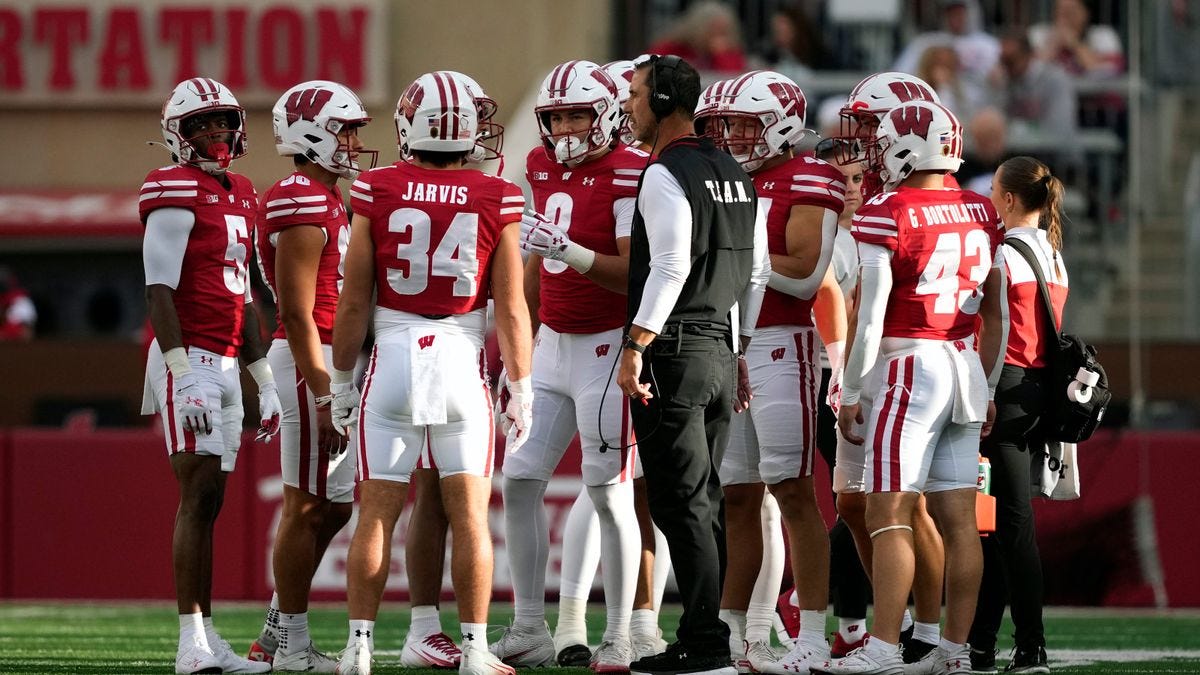 Wisconsin Badgers head coach Luke Fickell stands on the sideline with players at Camp Randall Stadium. Wisconsin Badgers head coach Luke Fickell stands on the sideline with players at Camp Randall Stadium.
