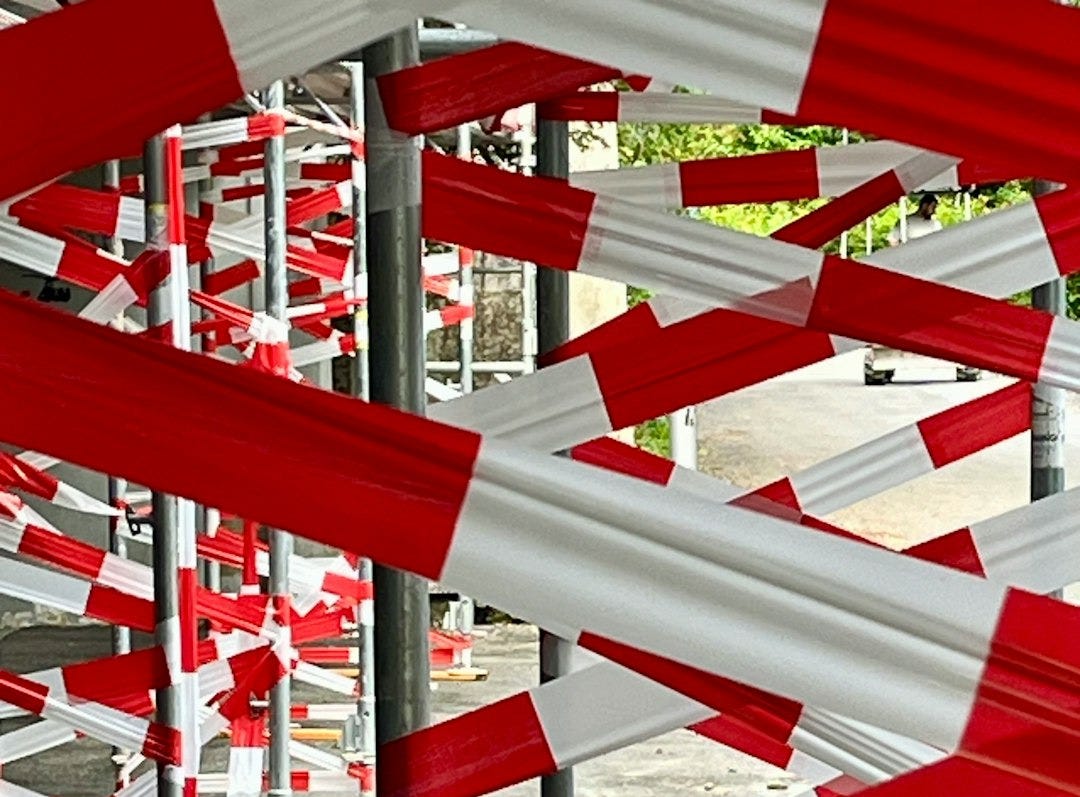 A bunch of red and white barriers in a parking lot A bunch of red and white barriers in a parking lot